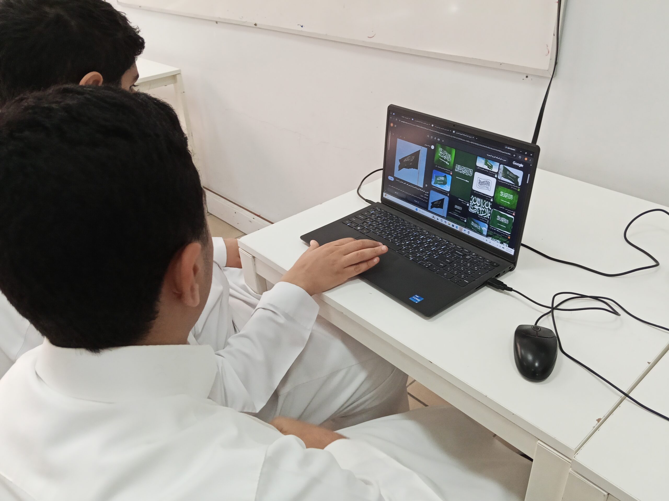 طلاب نادي التقنية الرقمية أثناء تنفيذ تصاميم اليوم الوطني السعودي